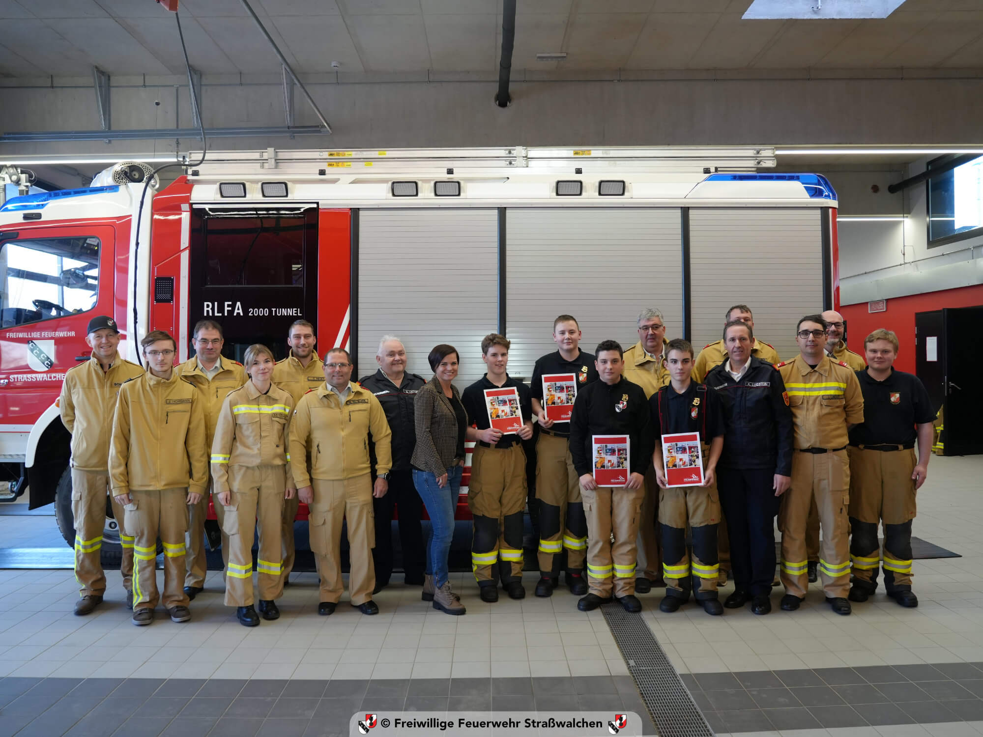 Gruppenfoto der Feuerwehrjugend Straßwalchen mit Urkunden im Feuerwehrhaus.