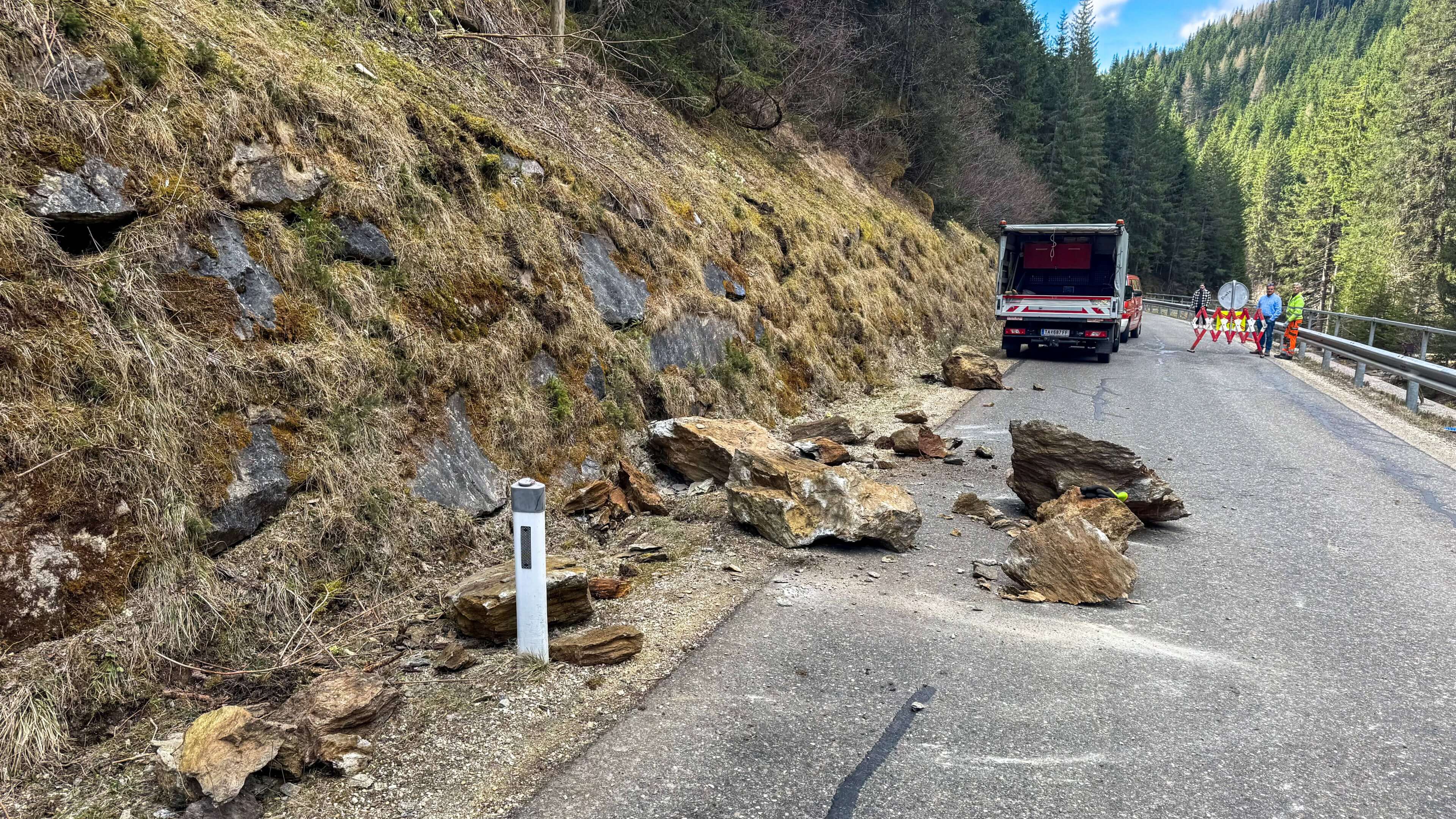 Felssturz auf der L262 mit blockierter Straße, Feuerwehr im Einsatz zur Sicherung.
