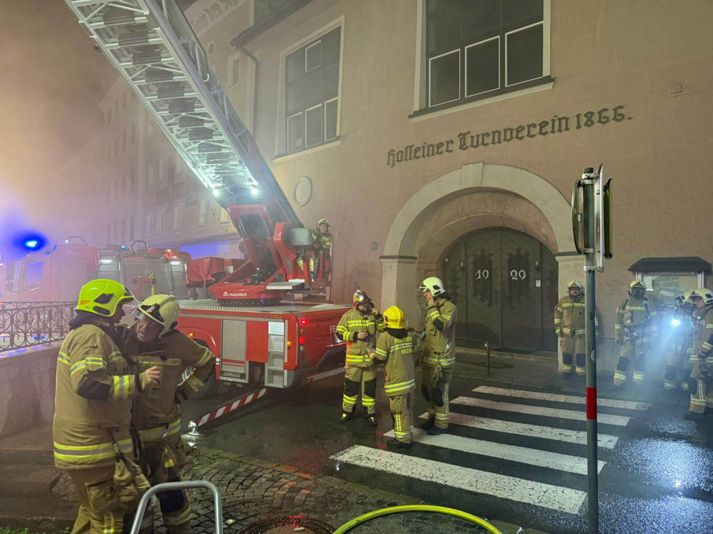 Feuerwehrleute im Einsatz vor historischem Gebäude in Salzburg, Einsatzkräfte und Ausrüstung
