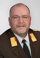 Porträt eines Feuerwehrmanns in Uniform des Landesfeuerwehrverbands Salzburg mit Abzeichen